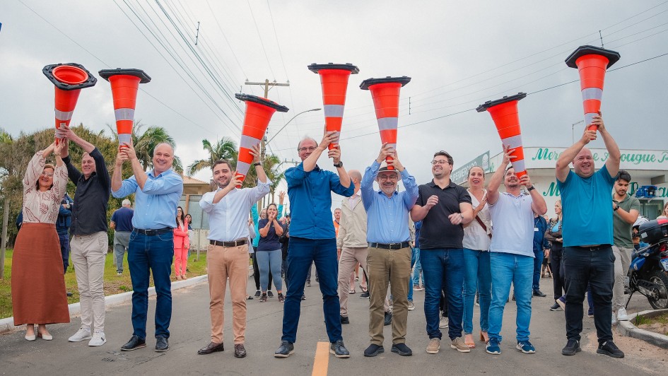 Uma foto externa de um grupo de cerca de 18 homens posando para a câmera em frente a um prédio moderno, possivelmente em um campus de pesquisa ou inovação. A maioria dos homens veste roupas casuais de negócios, como blazers, camisas polo ou casacos leves.

O grupo está reunido em frente a uma placa de sinalização de metal cinza com o logotipo e o nome: "NEBRASKA INNOVATION CAMPUS" e "Greenhouse Innovation Center" em letras grandes, indicando o local da visita.

O edifício ao fundo é moderno, com fachada de cor clara (cinza claro e bege) e amplas janelas horizontais escuras. O gramado em primeiro plano está verde e há uma árvore frondosa e uma luminária de rua no canto direito. O céu está nublado, e a comitiva parece estar em uma missão de pesquisa em irrigação ou tecnologia agrícola nos EUA.