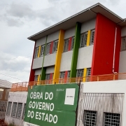 Imagem mostra a fachada da escola Margarida Pardelhas, com detalhes coloridos e placa de obras pelo governo do Estado.