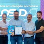 Cinco homens em traje formal com segurança documento conjunto diante de tela com mensagem sobre integração regional.