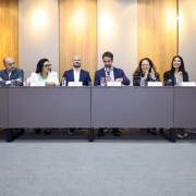 Governador Eduardo Leite com secret&aacute;rios e autoridades est&atilde;o sentados lado a lado numa mesa.