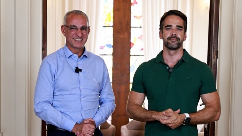 A imagem mostra o governador Eduardo Leite e o titular da SSPS, Jorge Pozzobom, sorrindo e posando lado a lado para a foto. 