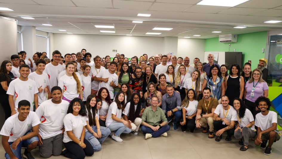 A imagem mostra um grupo grande de pessoas reunidas posando para a foto em uma sala ampla. Ao centro, est&aacute; o secret&aacute;rio de Desenvolvimento Social. H&aacute; muitos jovens vestindo camisetas brancas de uniformes. 