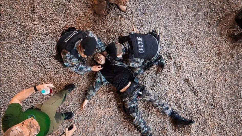 Foto mostra treinamento de policiais. Um deles simula uma v&iacute;tima ca&iacute;da no ch&atilde;o e outros dois v&atilde;o atend&ecirc;-lo.