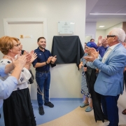 Vice-governador Gabriel Souza e secret&aacute;ria Arita Bergmann em frente a placa com outras autoridades. Todos batem palmas. 