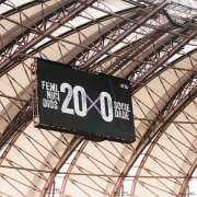 Um tel&atilde;o pendurado em uma estrutura met&aacute;lica de est&aacute;dio exibe a mensagem &ldquo;Feminic&iacute;dios 20 x 0 Sociedade&rdquo;, destacando um placar simb&oacute;lico contra a viol&ecirc;ncia de g&ecirc;nero.