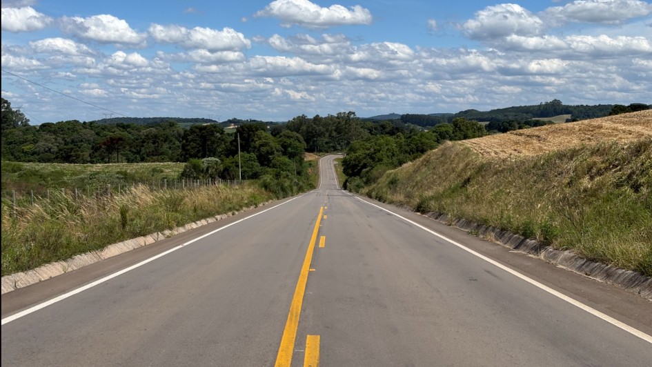 Foto mostra estrada nova, bem no meio da rodovia que segue at&eacute; o infiinito em uma &aacute;rea de mata.O c&eacute;u est&aacute; claro com algumas nuvens. 