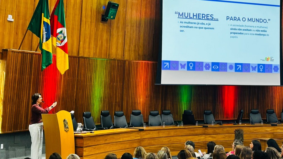 Foto secret&aacute;ria F&aacute;bia discursando no p&uacute;lpito diante de plateia.