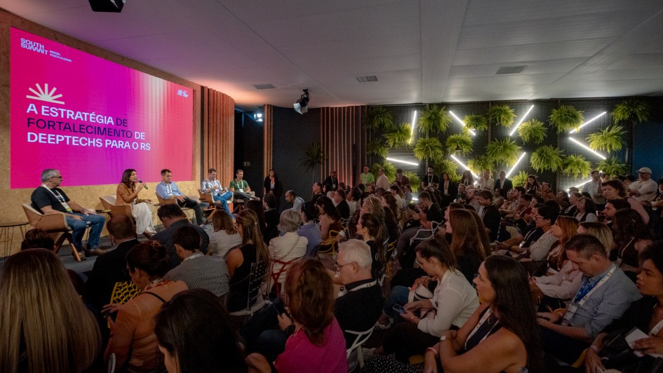 Foto mostra palestrantes falando para plateia.