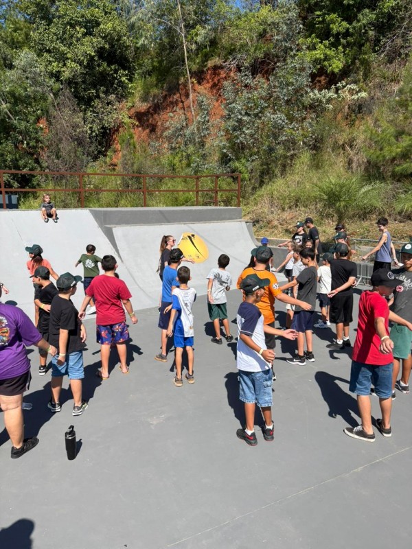 vários jovens de frente para rampas de skate fazendo exercícios físicos