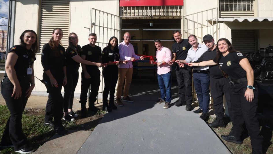 A imagem mostra um grupo alinhado em frente a um pr&eacute;dio de fachada clara com o letreiro &ldquo;bebec&ecirc;&rdquo; acima da entrada. As pessoas est&atilde;o posicionadas dos dois lados de uma faixa vermelha estendida, em um gesto simb&oacute;lico de inaugura&ccedil;&atilde;o. Grades met&aacute;licas, janelas com prote&ccedil;&atilde;o e parte externa pavimentada comp&otilde;em o cen&aacute;rio.