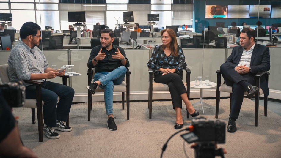 Foto mostra o vice-governador Gabriel Souza falando durante o podcast. Ele &eacute; acompanhado pelo apresentador e outros dois participantes do podcast.