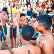 C&iacute;rculo de crian&ccedil;as e adolescentes ind&iacute;genas dan&ccedil;ando com pintura corporal e segurando objetos ind&iacute;genas durante a entrega da reforma na escola ind&iacute;gena Fag Nhin.