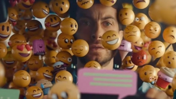 Rosto de motorista &eacute; quase todo coberto por e-motions semelhantes aos usados em mensagens de whats. Imagem destaca perigo do uso de celular por motorista em tr&acirc;nsito.