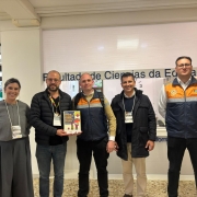 Foto mostra comitiva. S&atilde;o quatro homens e uma mulher. Dois deles est&atilde;o com coletes laranjas e azuis da Defesa Civil.