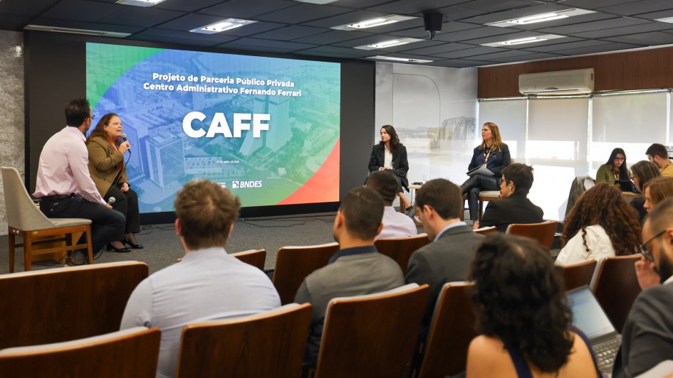Foto mostra apresenta&ccedil;&atilde;o do projeto. No palco quatro debatedores falam sobre a proposta diante da plateia. 