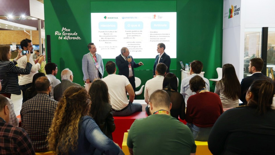 Foto mostra secret&aacute;rio Paim e integrantes do projeto apresentando proposta diante da plateia. 