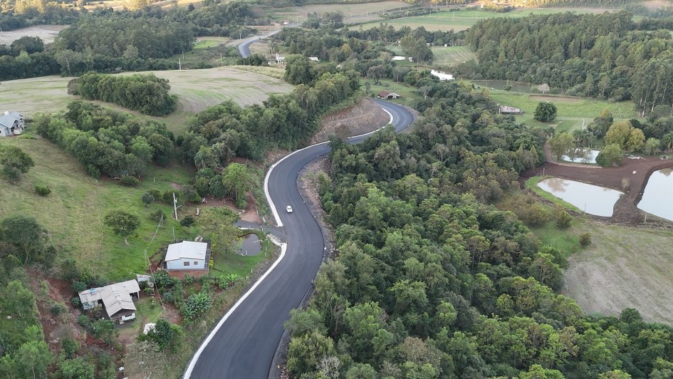 Vista a&eacute;rea de uma rodovia asfaltada recentemente, com tra&ccedil;ado sinuoso atravessando &aacute;rea rural.