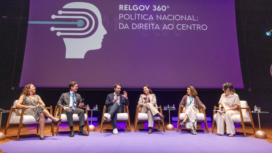 Foto de um palco com seis palestrantes sentados em poltronas. O governador do RS est&aacute; ao centro. Ao fundo, em um painel l&ecirc;-se "RELGOV 360&ordm; Pol&iacute;tica Nacional: da direita ao centro".