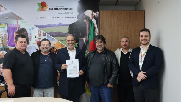 Foto mostra secret&aacute;rio Gustavo Paim e representantes de munic&iacute;pios contemplados.