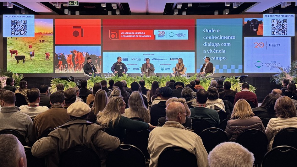 Foto mostra painelistas do congresso no palco, falando para a plateia.