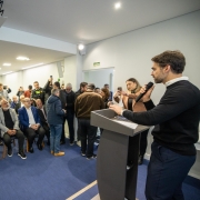 Foto mostra governador Eduardo Leite discursando diante da plateia.