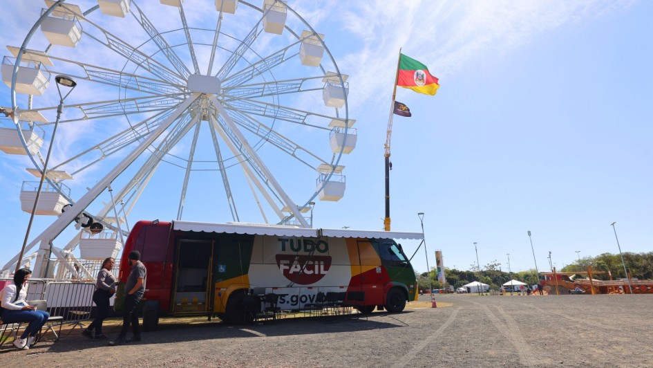 Foto mostra a unidade do Tudo F&aacute;cil no p&aacute;tio do Acampamento Farroupilha. Ao fundo, aparece a roda gigante. O c&eacute;u est&aacute; azul.