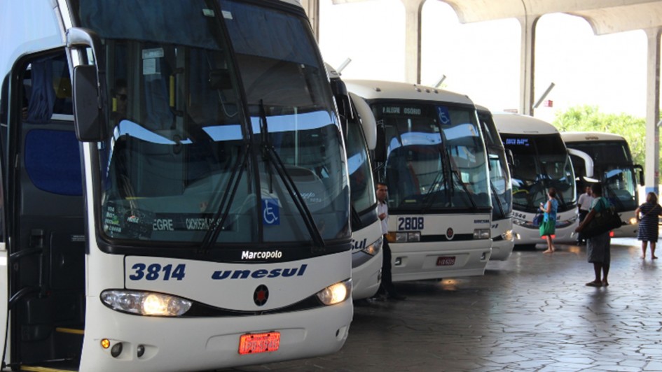 Foto mostra &ocirc;nibus enfileirados numa rodovi&aacute;ria. 