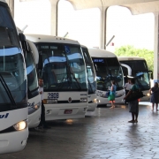Foto mostra &ocirc;nibus enfileirados numa rodovi&aacute;ria. 